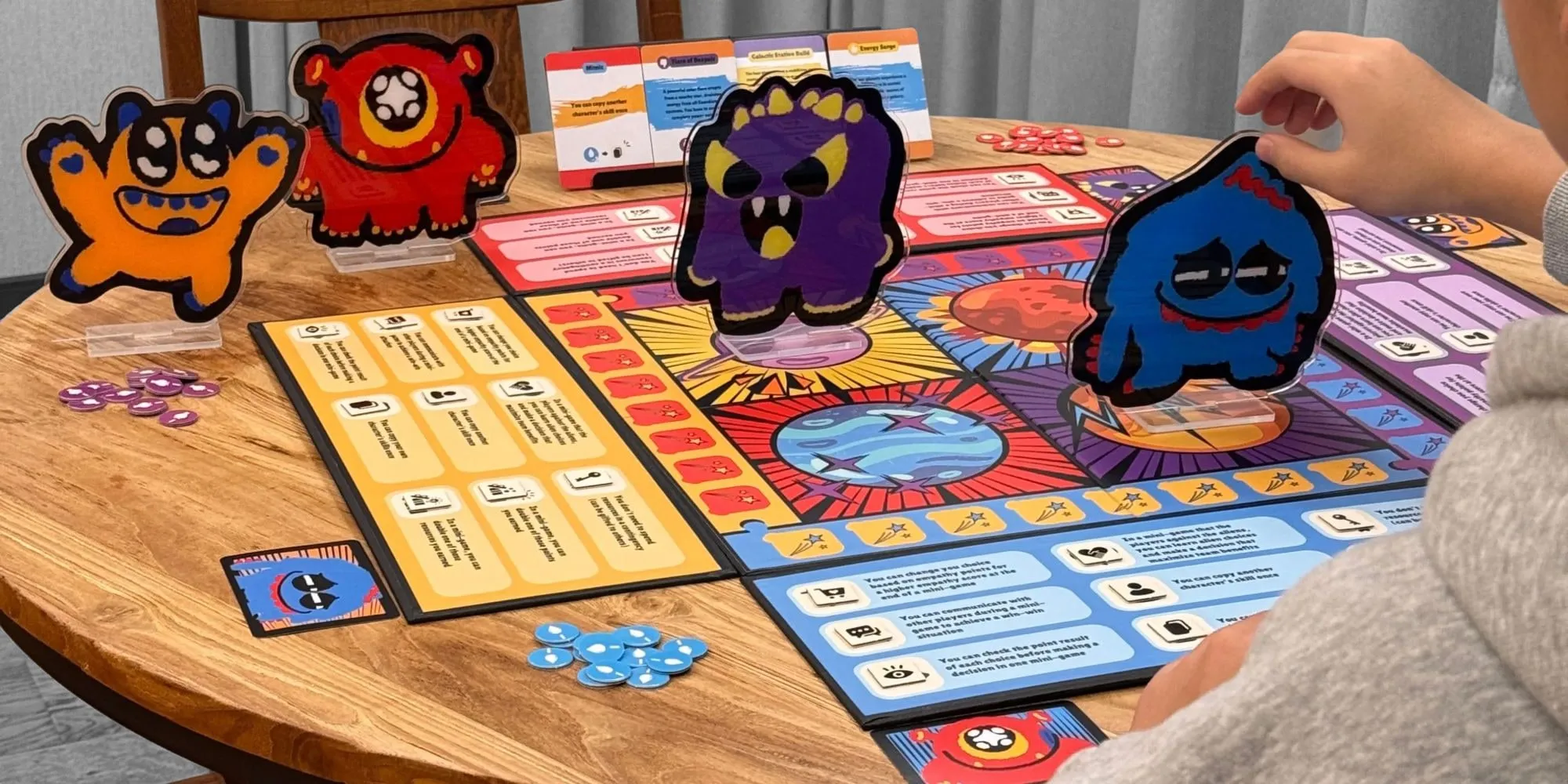 The Galactic Guardians board game on a round wooden table, with the character standees, event cards and resource tokens, as a player moves the blue character