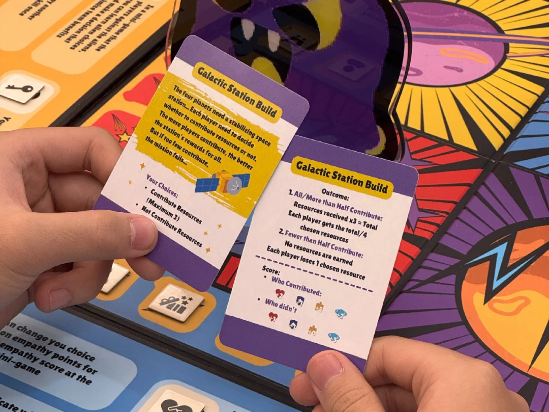 Product trial photo: a player holds the Galactic Station Build mini-game card and its outcome card