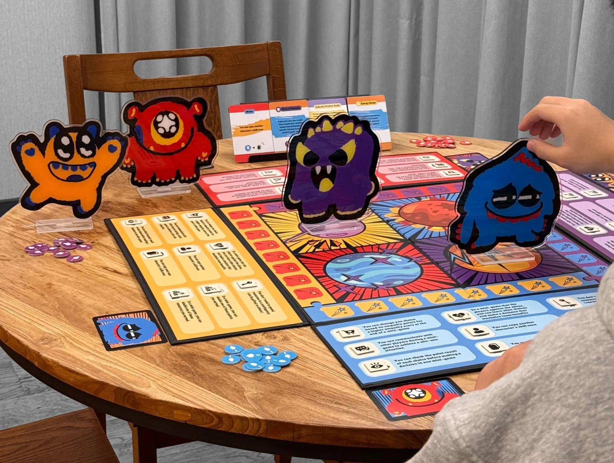 The Galactic Guardians board game on a round wooden table, with the character standees, event cards and resource tokens